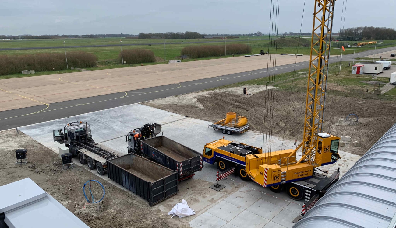 Dakgrind kubelen met hijskraan en containerauto