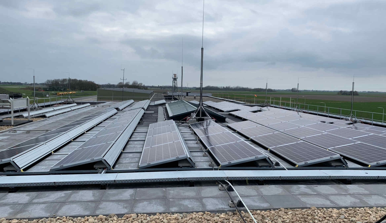 Grindkubelen tussen zonnepanelen platdak